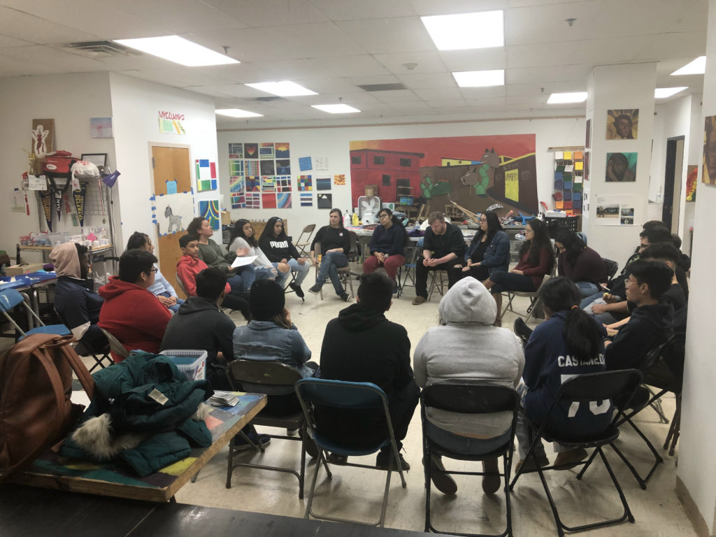 Large group of students sitting in a circle during a high school group meeting