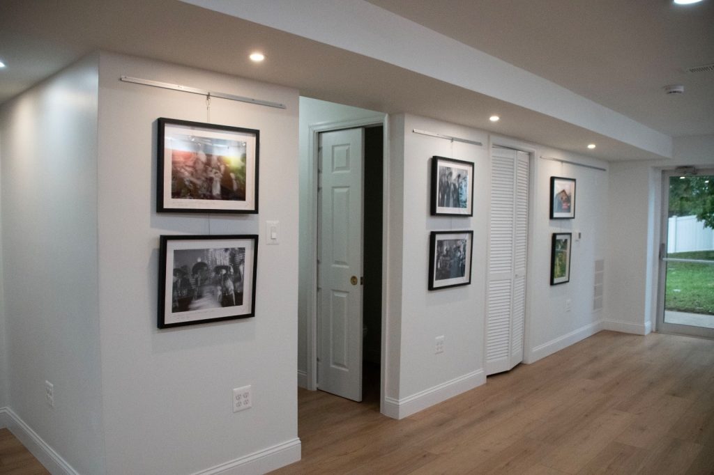 Framed black-and-white photographs hanging along a white gallery hallway