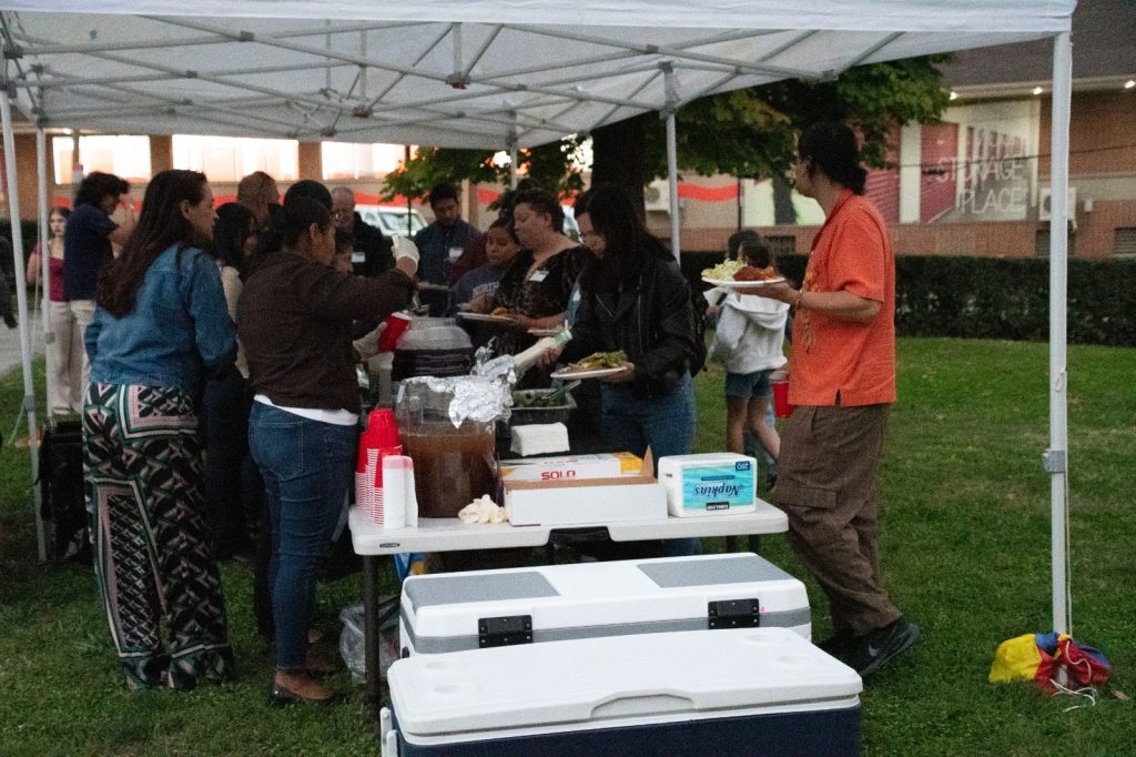 Guests lining up and filling their plates under a white tent