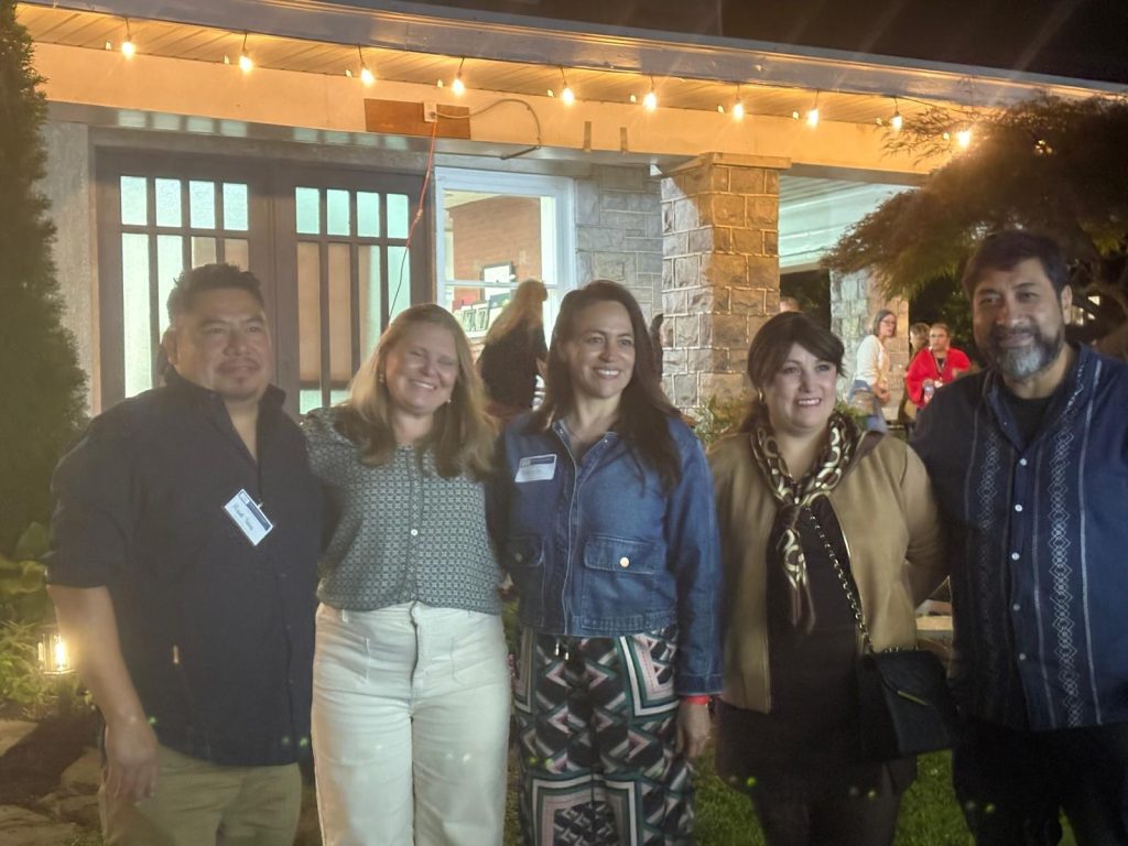 Five members of CCATE’s remodeling committee standing together on the porch at night